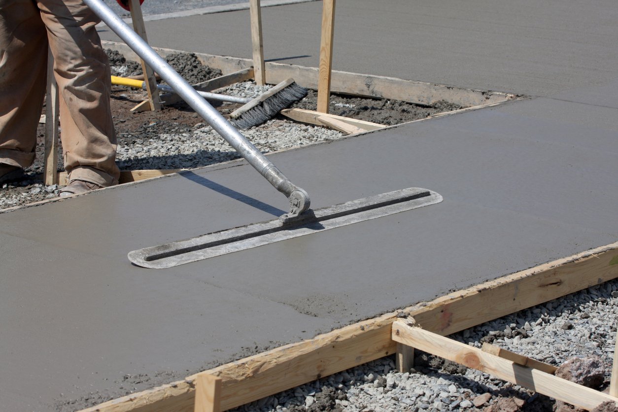 Freshly poured concrete is floated on a sidewalk construction project.